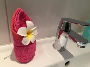 a pink towel with a flower on a sink at Exclusive Living Apartment 2 Zimmer bis zu 4 Personen in Nürnberg