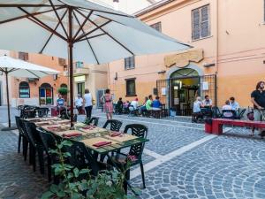 - une table avec un parasol dans une rue dans l'établissement La Casa degli Artisti, à Nettuno