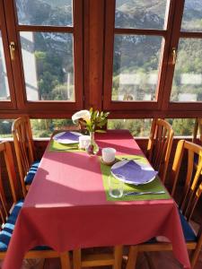 a table with a pink table cloth on it with windows at El interior de Gaia in Arriondas