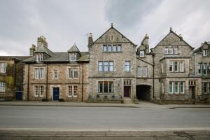 ein altes Steingebäude mit einer Straße davor in der Unterkunft Absoluxe Suites in Kirkby Lonsdale