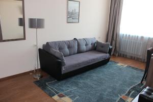 a couch in a living room with a blue rug at Гостиница ОКА in Kaluga