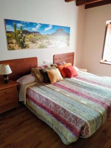 a bedroom with a bed with a colorful quilt at El interior de Gaia in Arriondas