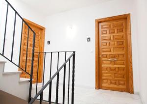 einen Flur mit Holztür und Treppe in der Unterkunft 1.1 Apartamentos Arguiñan in Córdoba