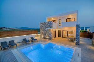 a villa with a swimming pool in front of a house at Prasonisi Villas in Kattavía
