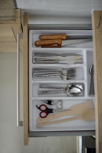 un cajón lleno de tijeras y otros utensilios de cocina en APARTAMENT PRZYTULNY, en Kielce 13 fotos más