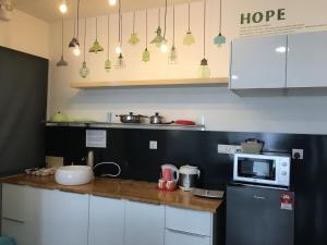eine Küche mit einer Theke, einer Mikrowelle und einem Kühlschrank in der Unterkunft Woodsbury by Micheal Butterworth Penang 7722 in Butterworth