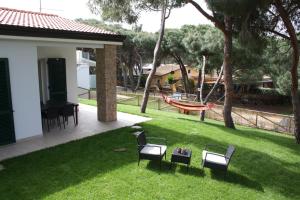 um quintal com cadeiras, uma mesa e uma rede de descanso em Rosa Dei Venti em Valledoria