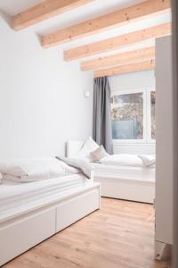 Duas camas num quarto branco com uma janela em Ferienwohnung Otto-Dill-Halle em Appenthal