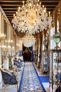 a hallway with chandeliers and blue and white furniture at Château De Beauvois - La Maison Younan in Saint-Étienne-de-Chigny