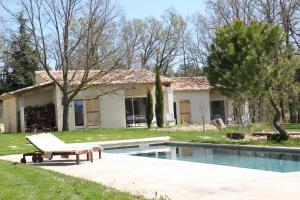 une maison avec une piscine et un banc à côté dans l'établissement Le Fournil en Provence, à Caseneuve