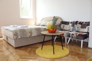 Un dormitorio con una mesa con una piña y una cama en Apartman Studio 2, en Brčko