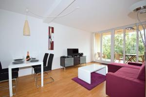ein Wohnzimmer mit einem lila Sofa und einem Tisch in der Unterkunft Berlin Habitat in Berlin