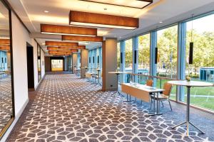 an empty lobby with tables and chairs and windows at Steigenberger Hotel Köln in Cologne