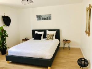 a bedroom with a bed with white sheets and pillows at VILLA BIRDS in Boran-sur-Oise