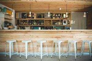 un bar con taburetes blancos en un restaurante en Centro de Ecoturismo Tierra del Agua, en Caleao