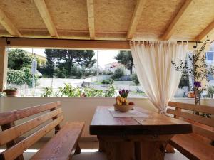 comedor con mesa, bancos y ventana grande en Apartment Cactus, en Okrug Donji