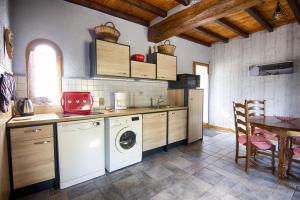 a kitchen with a washing machine and a table at Gite Au Chant des Vents in Thurageau