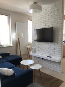 a living room with a tv on a white brick wall at Apartament w samym sercu Opola in Opole