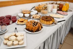 una mesa con pasteles y otros postres. en Hotel Tres Cruces, en Montevideo