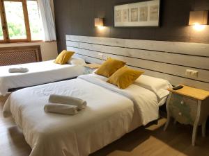 a bedroom with two beds with yellow pillows on them at Hotel Torrecerredo in Arenas de Cabrales