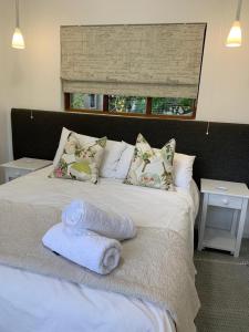 a bed with towels on it with a window at 15 Arbour Road Apartment in George