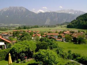 a small town in a green field with mountains at Gästehaus Katharina in Kiefersfelden