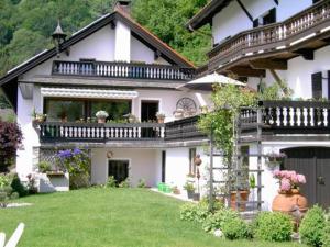 ein weißes Haus mit einem Balkon und einem Hof in der Unterkunft Gästehaus Katharina in Kiefersfelden
