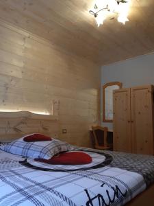 una camera con un letto e una parete in legno di Casa ai Ross a Valdisotto