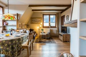 a dining room and living room with a table and chairs at Apartment Tiffany in Nowe Bystre