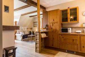 kuchnia z drewnianymi szafkami i salon w obiekcie Apartment Tiffany w mieście Nowe Bystre