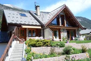 a house with a porch and stairs in front of it at Partie de chalet in Saint-Chaffrey