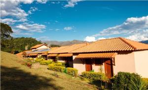 ein Haus mit orangefarbenem Dach auf einem Hügel in der Unterkunft Pousada Fazenda do Engenho in Serra do Cipo