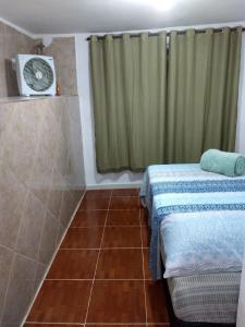 a small room with a bed and a fan at Hospedagem Céu Azul in Cachoeira Paulista