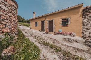 a small house on a dirt road next to a building at La Casa Di Nonna in Koríthion