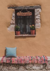 a window with two potted plants on a building at La Casa Di Nonna in Koríthion