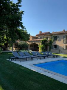 a row of lounge chairs next to a swimming pool at FOUR DE CONY in Saumane-de-Vaucluse