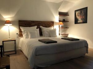 a bedroom with a large white bed with two lamps at FOUR DE CONY in Saumane-de-Vaucluse