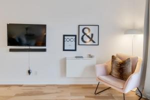 a living room with a chair and a tv at INITIAL - VOGUE HC - Vieux-Limoilou in Quebec City