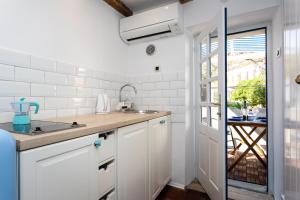 a kitchen with white cabinets and a sink at Little house in Baška in Baška