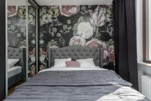ワルシャワにあるChill Apartments Wolaの花柄の壁紙を用いたベッドルーム1室(大型ベッド1台付)