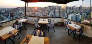 a restaurant with tables and chairs and a view of a city at Musk Hotel in Istanbul