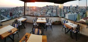 ein Restaurant mit Tischen und Stühlen und Stadtblick in der Unterkunft Musk Hotel in Istanbul