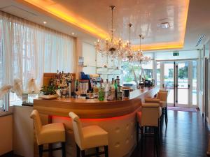 a bar in a restaurant with a counter and chairs at Hotel Ca' D'Oro in Bibione