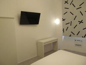 um quarto com uma televisão numa parede com uma secretária em Old Town Guest House em Gênova