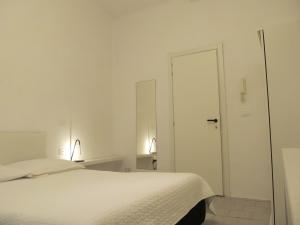 a white bedroom with a bed and a mirror at Old Town Guest House in Genoa