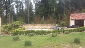 a backyard with a swimming pool and a house at La Roussilhe in Sousceyrac