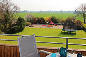 - Balcón con mesa y sillas y parque infantil en Meeresblick Fehmarn, en Fehmarn