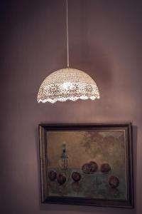 a chandelier hanging from a ceiling with a painting at La Casa Di Nonna in Koríthion