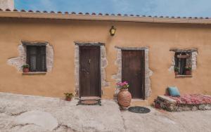 a building with two doors and a vase with flowers at La Casa Di Nonna in Koríthion