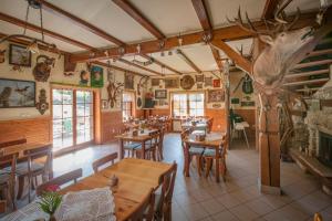 a restaurant with wooden tables and chairs in a room at Hubertus Pokoje Gościnne in Sienna